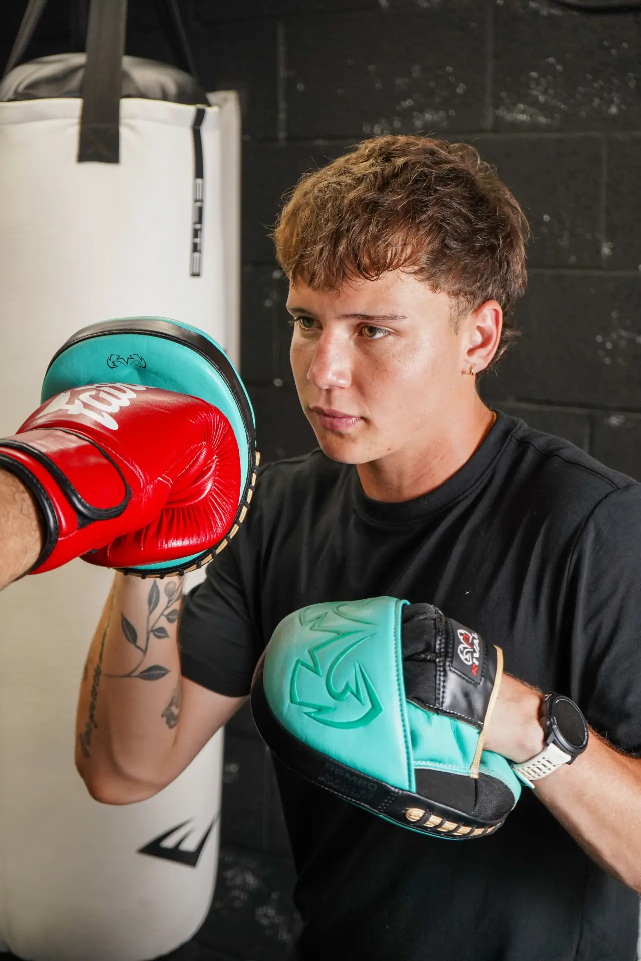 Close-up of Coach Caden holding the mitts during a private session