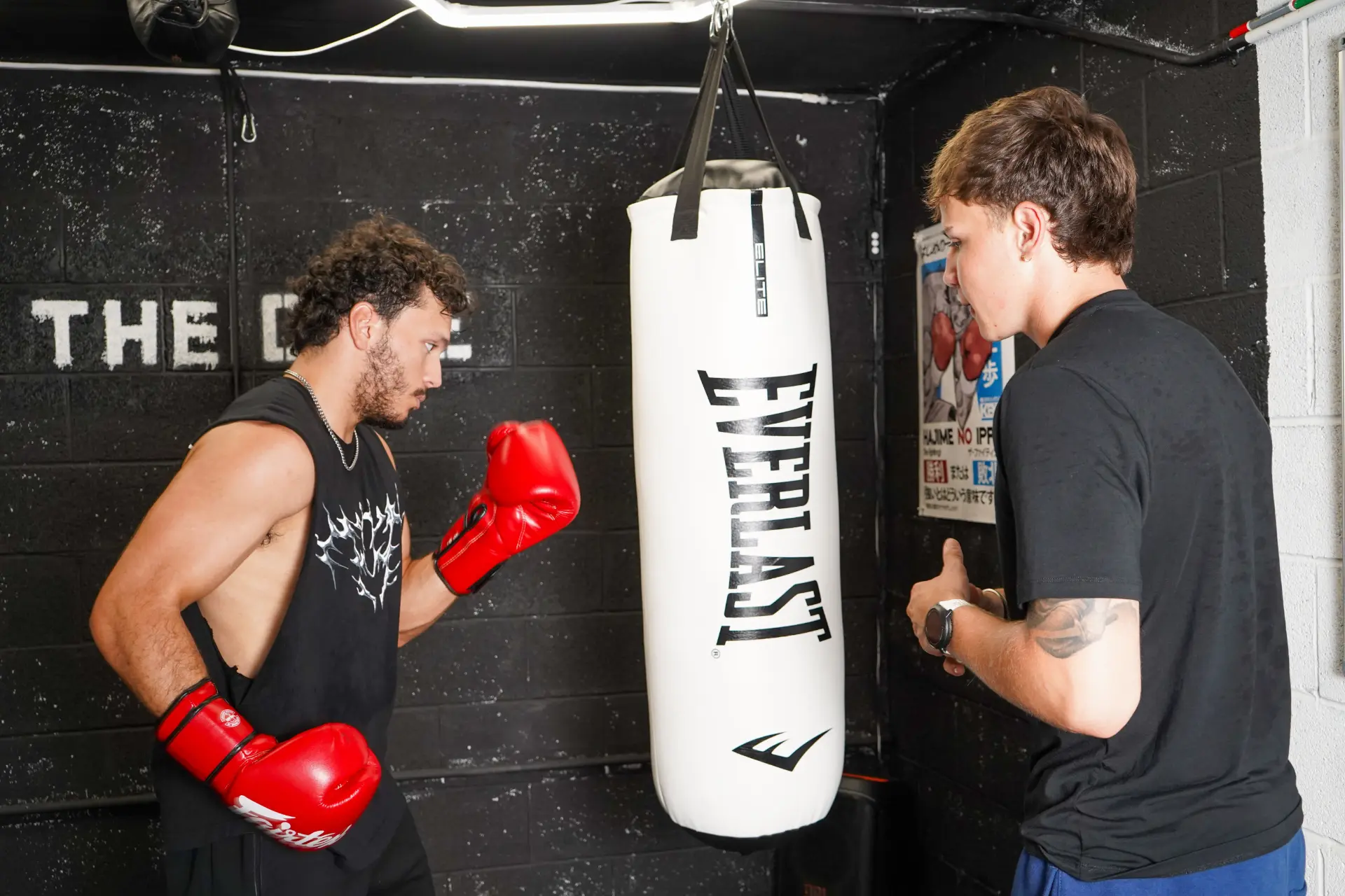 Coach Caden squared up with a fighter at the heavy bag inside The Cave